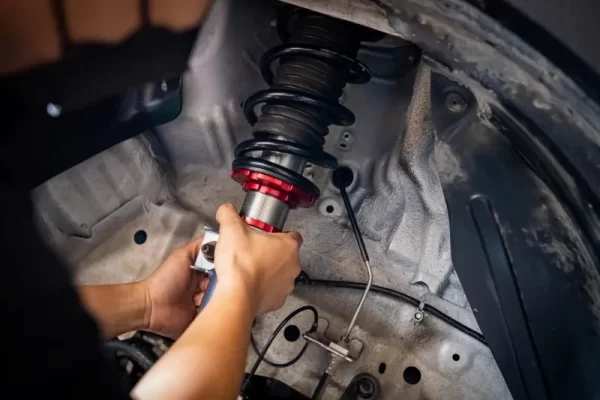 ช่างกำลังติดตั้งโช๊คอัพยี่ห้อ Profender สีดำ แกนสีเงิน