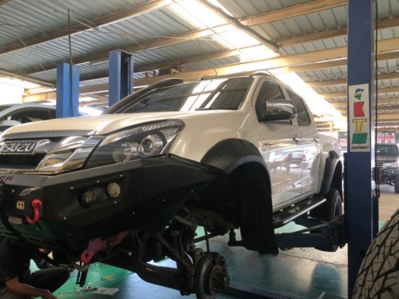 รถกระบะ ISUZU สีขาว จอดอยู่ในโรงซ่อม