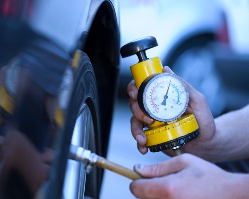 ช่างกำลังเช็คลมยางรถยนต์ โดยใช้อุปกรณ์