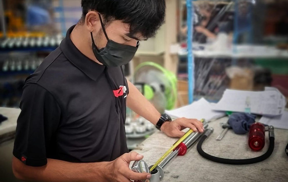 ช่างผู้ชายกำลังวัดขนาดโช๊คอัพ Profender สีเงินตัดแดง