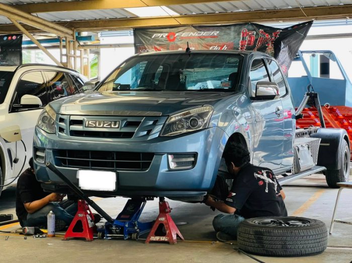 ช่างซ่อมช่วงล่างรถกระบะอีซูซุ ในโรงซ่อมรถ
